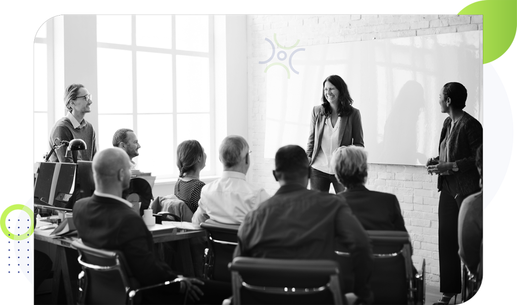 group of people listening to a speaker in an office environment